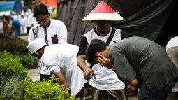 Peserta aksi damai 212 mengambil air wudhu dengan botol air minum untuk berwudhu di Monas, Jakarta, Jumat (2/12). Dikarenakan penuhnya tempat wudhu yang telah disediakan Peserta mengambil wudhu dengan botol air minum. (Liputan6.com/Faizal Fanani)