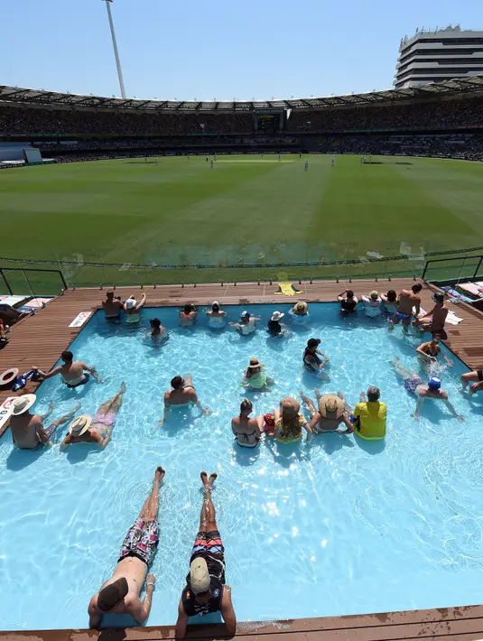 Sejumlah penonton berada di kolam renang menyaksikan pertandingan uji coba kriket antara Australia dan Pakistan di dalam stadion Gabba di Brisbane, Australia (15/12). (AFP Photo/Saeed Khan)