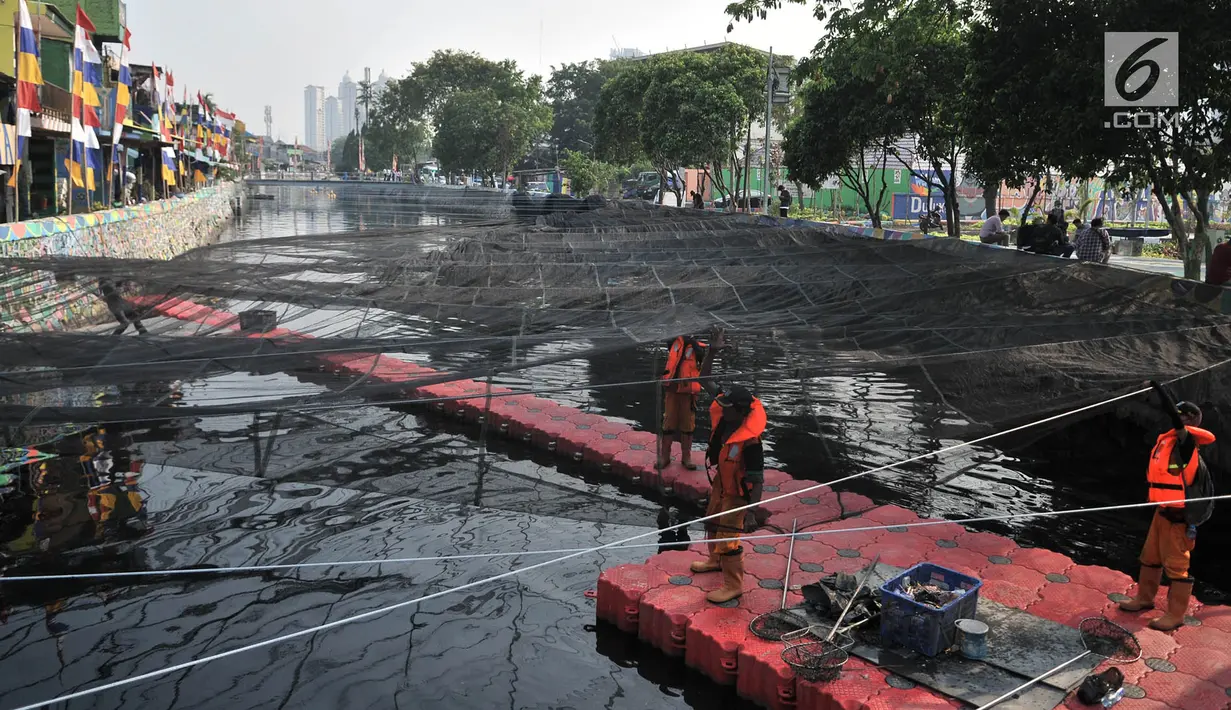 Petugas Dinas Sumber Daya Air DKI Jakarta memasang waring di Kali Sentiong atau Kali Item, Tanjung Priok, Selasa (31/7). Pemprov DKI Jakarta menambah pemasangan waring sepanjang 100 m hingga Stasiun Pompa Kali Item. (Merdeka.com/Iqbal S Nugroho)