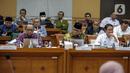 Dirjen Penyelenggaraan Haji dan Umrah (PHU) Hilman Latief (kanan) dan Kepala Badan Pengelola Keuangan Haji (BPKH) Fadlul Imansyah (tengah) menyampaikan paparan saat rapat dengar pendapat bersama Komisi VIII DPR di Kompleks Parlemen, Senayan, Jakarta, Selasa (14/2/2023). Pengumuman terkait besaran biaya haji terpaksa ditunda hingga besok lantaran pemerintah bersama Panja Komisi VIII DPR masih belum menemui kesepakatan. (Liputan6.com/Faizal Fanani)