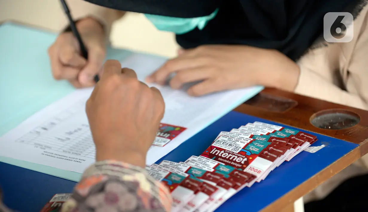 Guru membagikan kartu perdana Telkomsel dan Kuota 10 GB gratis kepada siswa kelas 7, 8 dan 9 SMPN 18, Pondok Benda, Pamulang, Tangsel, Kamis (10/9/2020). Program Kartu Perdana Merdeka itu untuk mendukung program pembelajaran jarak jauh (PJJ) di masa pandemi covid-19. (merdeka.com/Dwi Narwoko)