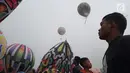 Seorang pria melihat balon udara dinaikan di Lapangan Pagerejo, Kertek, Kabupaten Wonosobo,  Sabtu (15/6/2019). Festival ini untuk memeriahkan syawalan dan wujud syukur warga yang hidup di lereng gunung sindoro dan sumbing. (Liputan6.com/Gholib)