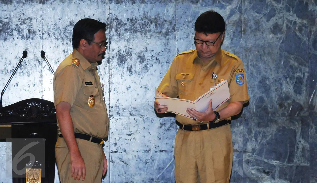 Mendagri Tjahjo Kumolo (kanan) mengecek nota penugasan jelang diserahkan ke Wagub DKI Djarot Saiful Hidayat di Balai Agung Jakarta, Selasa (9/5). Djarot menjabat Plt Gubernur hingga masa jabatannya habis, Oktober 2017. (Liputan6.com/Helmi Fithriansyah)
