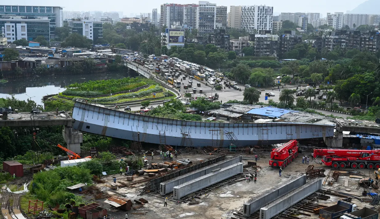 Bagian yang runtuh dari jembatan yang sedang dibangun di Mumbai, India (17/9/2021). Sedikitnya tiga belas orang terluka setelah bagian dari jembatan yang sedang dibangun runtuh di Persimpangan MTNL di Kompleks Bandra-Kurla di Bandra timur Jumat pagi. (AFP/Punit Paranjpe)