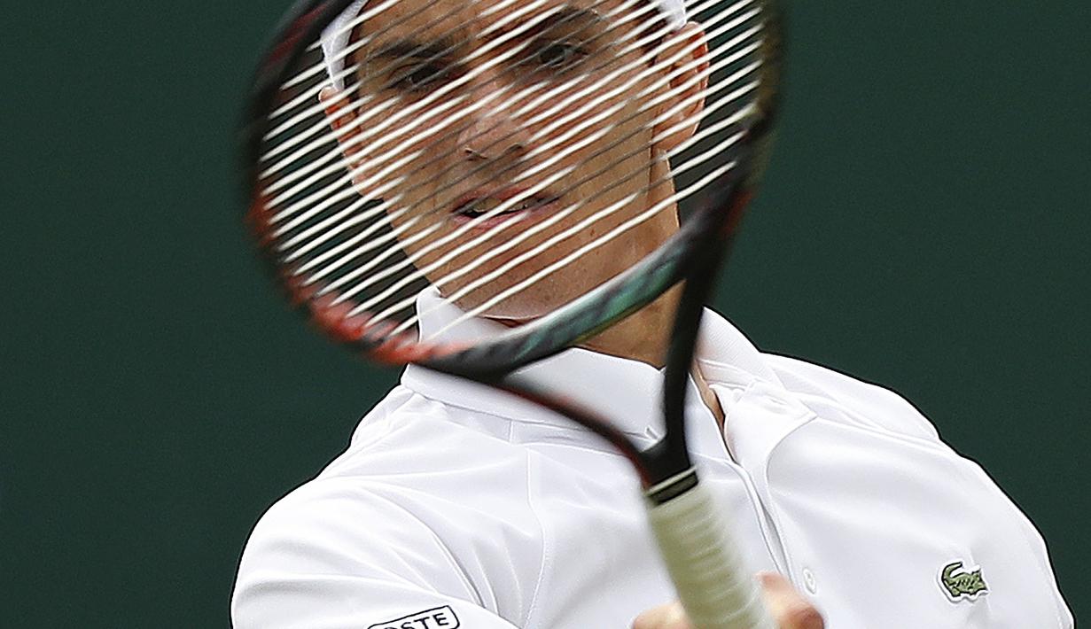 Pierre-Hugues Herbert saat mengembalikan bola ke arah lawannya dari Australia, Nick Kyrgios pada babak pertama Wimbledon 2017 di The All England Lawn Tennis Club, Wimbledon, London, (3/7/2017). Nick kalah karena cedera. (AFP/Adrian Dennis)