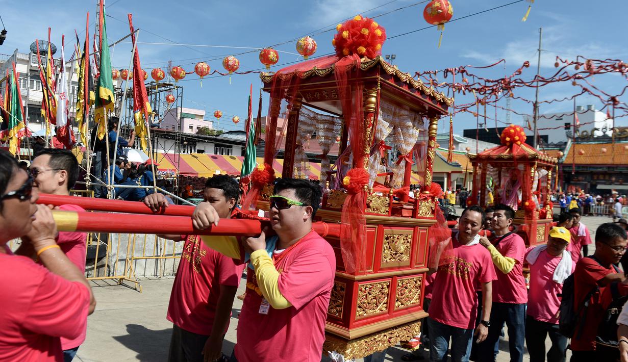 Warga keturunan Thailand-China mengarak kereta kayu yang membawa patung Dewi yang sangat dihormati dari Kuil Chao Mae To Mo saat merayakan festival keagamaan tahunan di distrik Sungai Kolok, Thailand (8/5). (AFP/Madaree Tohlala)