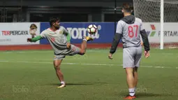 Pemain Bhayangkara FC, Ilham Udin (kiri) dan Ilija Spasojevic (kanan) menguji lapangan basah sebelum sesi latihan di Stadion Patriot Bekasi, Sabtu (11/11/2017). Latihan tersebut jelang melawan Persija. (Bola.com/Nicklas Hanoatubun)
