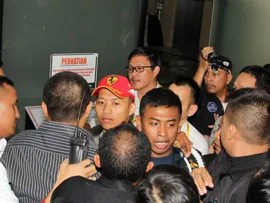 Rekan pengacara dari OCK and Associate mencoba menghalangi peliputan para wartawan yang hendak mengambil gambar salah seorang pengacara terduga pemberi suap, di Gedung KPK, Jakarta, (Liputan6.com/Helmi Afandi)