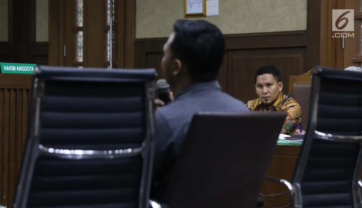 Bupati nonaktif Bener Meriah, Ahmadi (kanan) menyimak keterangan saksi saat menjalani sidang lanjutan dugaan suap alokasi dan anggaran Dana Otonomi Khusus Aceh di Pengadilan Tipikor, Jakarta, Senin (15/10). (Liputan6.com/Helmi Fithriansyah)