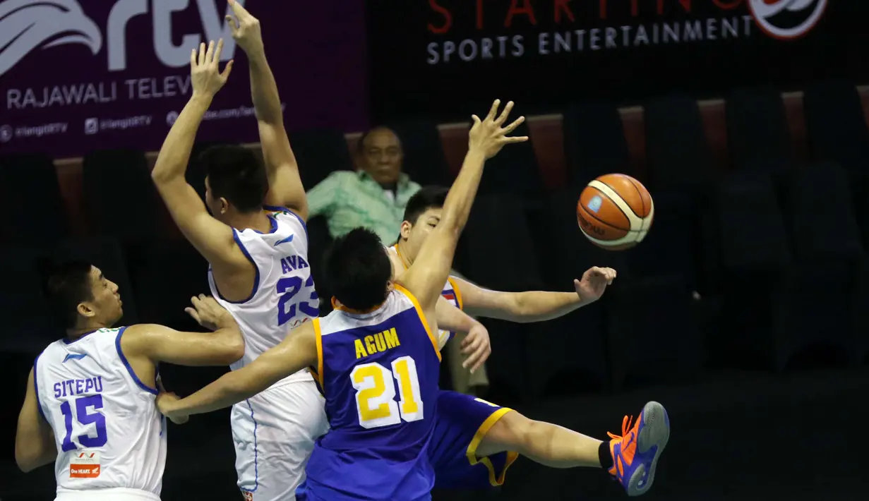 Pemain Satria Muda, Cristian Sitepu dan Avan Seputra menghalau tembakan pemain Bimasakti pada laga IBL Reguler Season di Hall A Senayan, Jakarta, Senin (11/1/2016). Satria Muda menang 55-33. (Bola.com/Nicklas Hanoatubun)