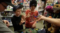 Dua orang anak memainkan fidget spinner di sebuah yang bernama toko Funky Monkey Toys di Oxford, Mich (11/5). Fidget spinner adalah sebuah mainan kecil yang bisa diputar dengan jari. (AP Photo / Carlos Osorio)