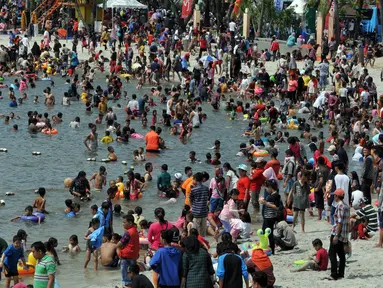 Pengunjung memadati pantai di Taman Impian Jaya Ancol, Jakarta, Kamis (7/7). Ancol tetap menjadi primadona tempat wisata bagi warga Jakarta dan sekitar untuk mengisi libur Lebaran. (Liputan6.com/Johan Tallo)