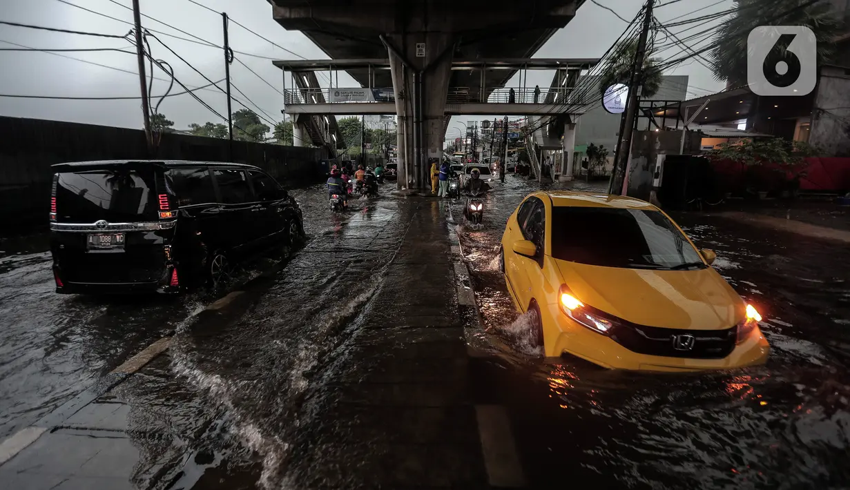 Sejumlah kendaraan menerobos Banjir yang menggenangi kawasan Seskoal - Cipulir, Jakarta, Selasa (4/4/2022). Hujan yang mengguyur wilayah Ibu Kota Jakarta mengakibatkan banjir menggenangi kawasan Simpang Seskoal, Kebayoran Lama, Jakarta. Banjir setinggi 50cm - 1 meter disebabkan saluran pembuangan berukuran kecil tersumbat. (Liputan6.com/Johan Tallo)