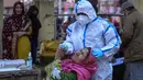Petugas kesehatan mengambil sampel swab seorang perempuan di sebuah pasar di Jammu, India, Rabu (29/12/2021). Di India, yang telah kembali normal setelah dihantam tsunami COVID-19 tahun ini, omicron sekali lagi menimbulkan ketakutan, dengan lebih dari 700 kasus dilaporkan. (AP Photo/Channi Anand)