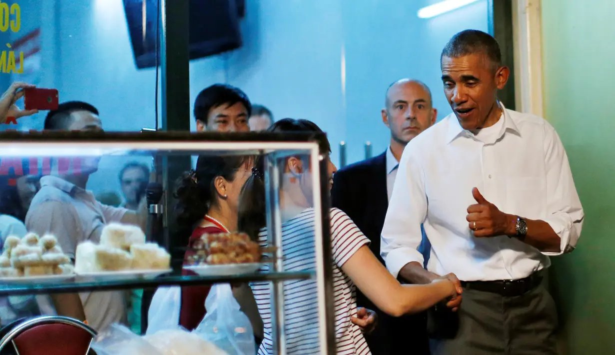 Presiden AS, Barack Obama berjabat tangan usai makan di warung sederhana bersama Anthony Bourdain di Hanoi, Vietnam (24/5). Kunjungan Obama ke Vietnam untuk mengakhiri larangan penjualan perlengkapan militer kepada pihak Hanoi. (REUTERS/Carlos Barria)