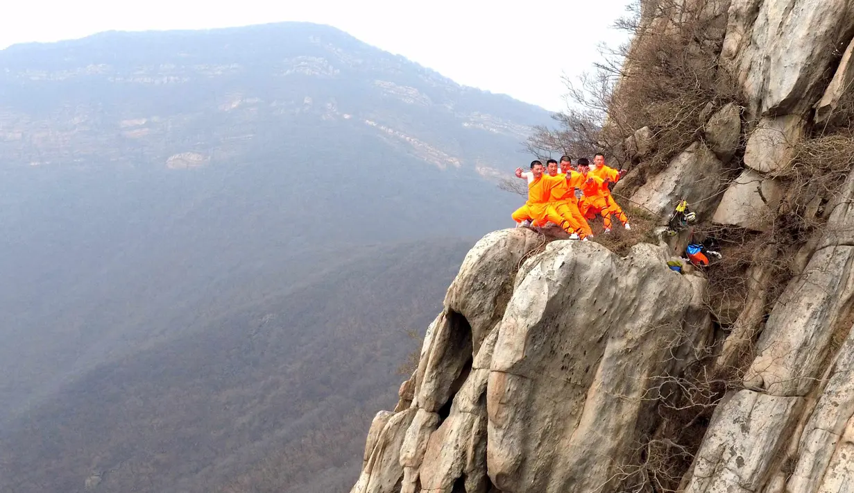 Sejumlah murid dari sekolah bela diri berlatih kungfu Shaolin di ujung tebing gunung  Songshan, , China , (17/3). Tanpa dibekali alat keamanan, Para murid ini melakukan gerakan ekstrem di tebing gunung. (REUTERS / China Daily)