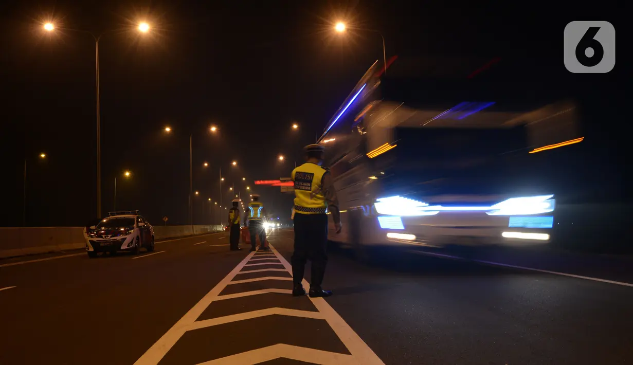 Petugas melakukan penyekatan arus mudik 2021 di gerbang pintu tol Pejagan, Brebes, Jawa Tengah, Jumat (7/5/2021) Tengah Malam, H-5 peniadaan mudik Idul Fitri 1442H dengan petugas gabungan melakukan penjagaan di 6 titik dari kabupaten menjadi pintu masuknya Jawa Tengah. (merdeka.com/Imam Buhori)