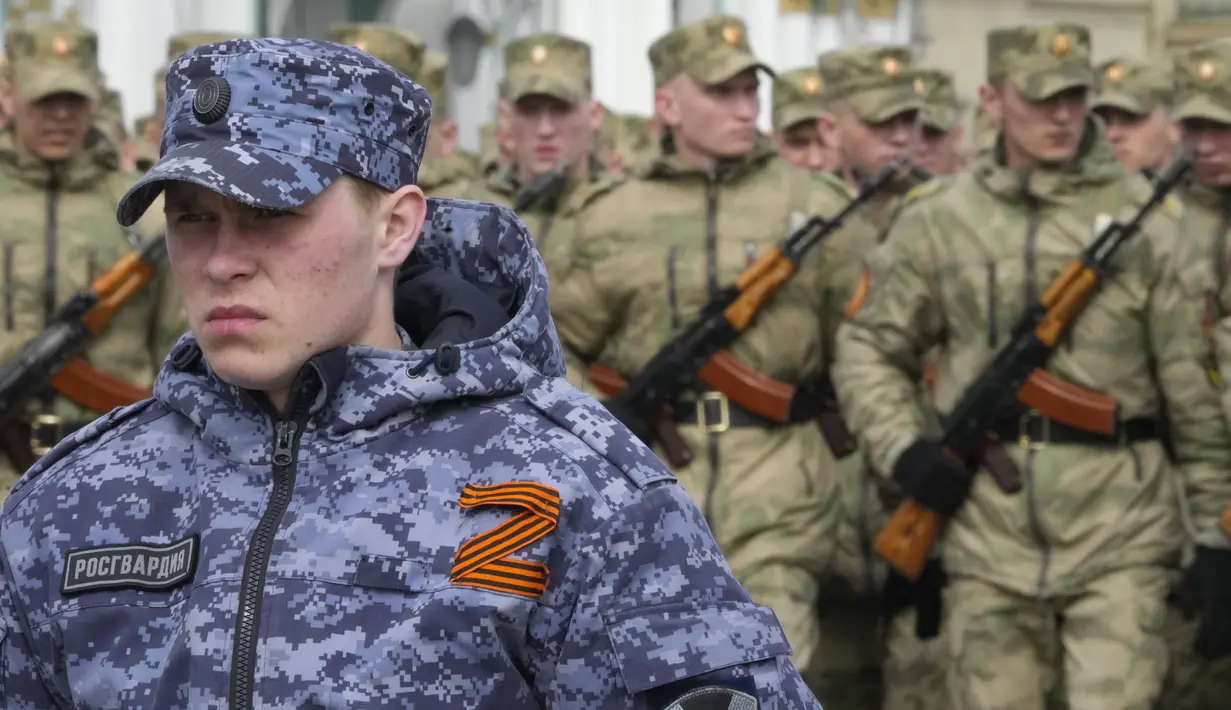 <p>Seorang prajurit Rusia Rosguardia (Pengawal Nasional) dengan huruf Z terlampir, yang telah menjadi simbol militer Rusia, berjaga-jaga selama latihan&nbsp;untuk parade militer Hari Kemenangan Perang Dunia II di St. Petersburg, Rusia, Selasa (26/4/2022). Rusia memperingati 77 tahun kemenangan dalam Perang Dunia II dengan menggelar parade militer yang akan berlangsung di Lapangan Dvortsovaya (Istana) pada 9 Mei 2022 mendatang. (AP Photo/Dmitri Lovetsky)</p>
