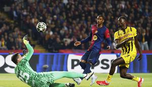 Kiper Barcelona, Wojciech Szczesny, melakukan penyelamatan dari ancaman yang dilakukan pemain Borussia Dortmund, Serhou Guirassy, dalam leg pertama perempat final Liga Champions 2024/2025 di Stadion Olimpic Lluis Companys, Kamis (10/4/2025) dini hari WIB. (AP Photo/Joan Monfort)