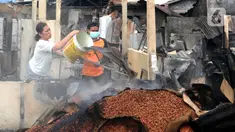 Pedagang menyiram air pada sisa bara api lokasi kebakaran Pasar Ciputat, Tangerang Selatan, Banten, Kamis (12/5/20222). Kebakaran Pasar Ciputat pada kemarin sore menghanguslan lebih dari 50 kios dan rumah warga yang berada di sekitar pasar. (merdeka.com/Arie Basuki)
