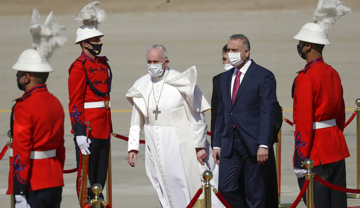 Paus Fransiskus disambut oleh PM Irak Mustafa al-Kadhimi saat tiba di Bandara Internasional Baghdad, Irak, Jumat (5/3/2021). Paus Fransiskus datang ke Irak untuk mendesak umat Kristen tetap tinggal dan membantu membangun kembali Irak setelah bertahun-tahun perang. (AP Photo/Andrew Medichini)