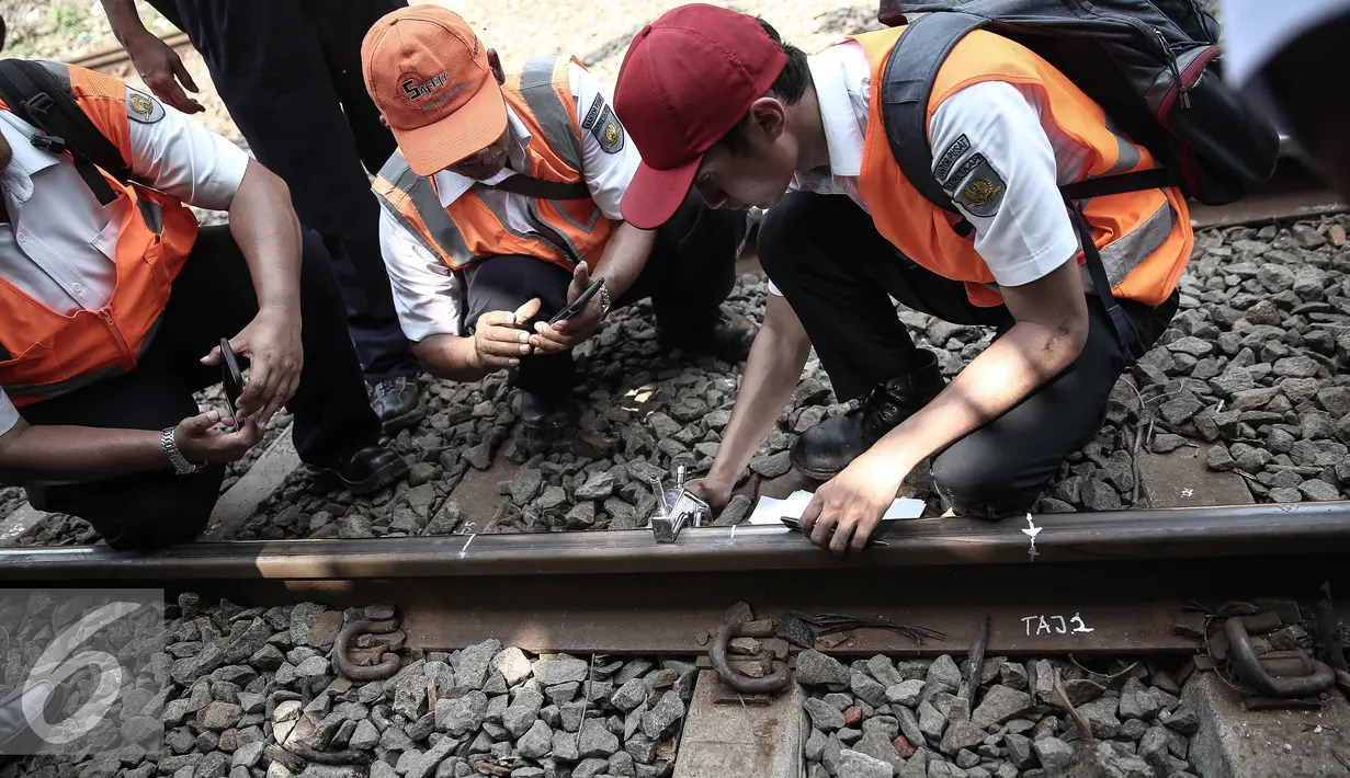 Petugas mengukur kerusakan rel pasca (KRL) Commuter Line Bogor-Tanah Abang yang anjlok di jalur Manggarai arah Sudirman, Jakarta, Rabu (18/5). KRL ka 1517 anjlok pada pukul 06.18 di km 5+4. (Liputan6.com/Faizal Fanani)