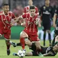 Pemain Real Madrid, Luka Modric jatuh saat berebut bola dengan pemain Bayern, Thiago dan James Rodriguez pada leg pertama semfinal Liga Champions di Allianz Arena, Munich, (25/4/2018). Real Madrid menang 2-1. (AP/Matthias Schrader)