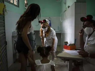 Perawat menyapa seorang anak yang tiba bersama ibunya untuk menerima dosis vaksin COVID-19 Soberana-02, di Havana, Kuba, Kamis (17/9/2021). Pemerintah Kuba memulai vaksinasi Covid-19 bagi anak-anak berusia 2 tahun dengan vaksin buatan dalam negeri. (AP Photo/Ramon Espinosa)