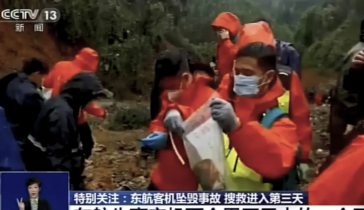 Pekerja darurat memasukkan perekam "kotak hitam" berwarna oranye ke dalam kantong plastik di lokasi kecelakaan pesawat Boeing 737-800 milik China Eastern Airlines  di Kabupaten Tengxian di Guangxi China selatan.