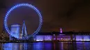 London Eye di tepi Sungai Thames diterangi dengan lampu biru untuk berterima kasih kepada National Health Service (NHS) di London, Kamis (7/1/2021). NHS merupakan sistem layanan kesehatan nasional yang menjadi ujung tombak Inggris dalam memerangi pandemi Covid-19. (AP Photo/Kirsty Wigglesworth)
