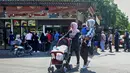 Warga Lebanon antre roti di depan toko roti di kota pesisir selatan Sidon, Jumat (13/8/2021). Tanpa masker, warga Lebanon berbondong-bondong ke toko roti sebelum fajar untuk membeli roti yang terjangkau di tengah krisis ekonomi parah yang memicu berbagai kelangkaan bahan pokok. (Mahmoud ZAYYAT/AFP)