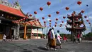 <p>Orang Bali mengenakan pakaian tradisional berjalan mengikuti doa di sebuah kuil Cina pada hari pertama Tahun Baru Imlek di Denpasar pada 1 Februari 2022. (SONY TUMBELAKA / AFP)</p>