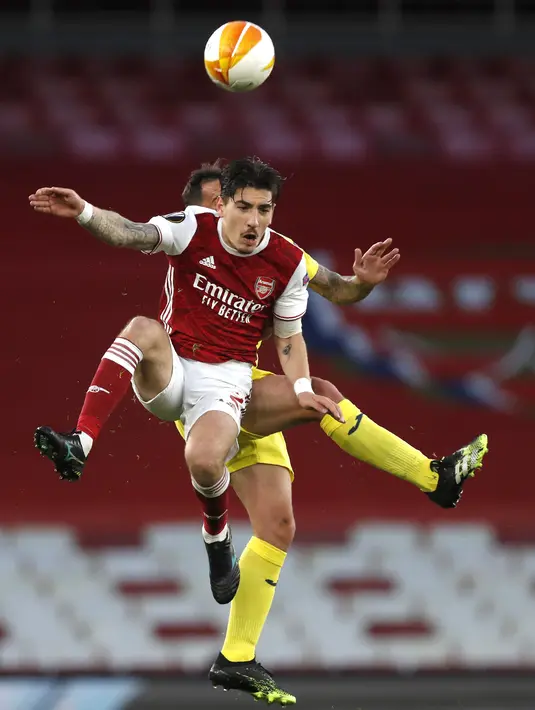Bek Arsenal, Hector Bellerin berebut bola dengan penyerang Villareal, Paco Alcacer pada leg kedua semifinal Liga Europa di Emirates Stadium, Jumat (7/5/2021) dinihari WIB. Villarreal menyingkirkan Arsenal dan lolos ke final setelah mencatatakan skor imbang 0-0. (AP Photo/Alastair Grant)