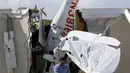 Pekerja mengevakuasi pesawat bermesin tunggal yang menabrak gedung di Bandara Regional Ak-Chin, Maricopa, Arizona, Amerika Serikat, Selasa (10/9/2019). FAA dan Dewan Keselamatan Transportasi Nasional masih menyelidiki penyebab kecelakaan. (AP Photo/Ross D. Franklin)