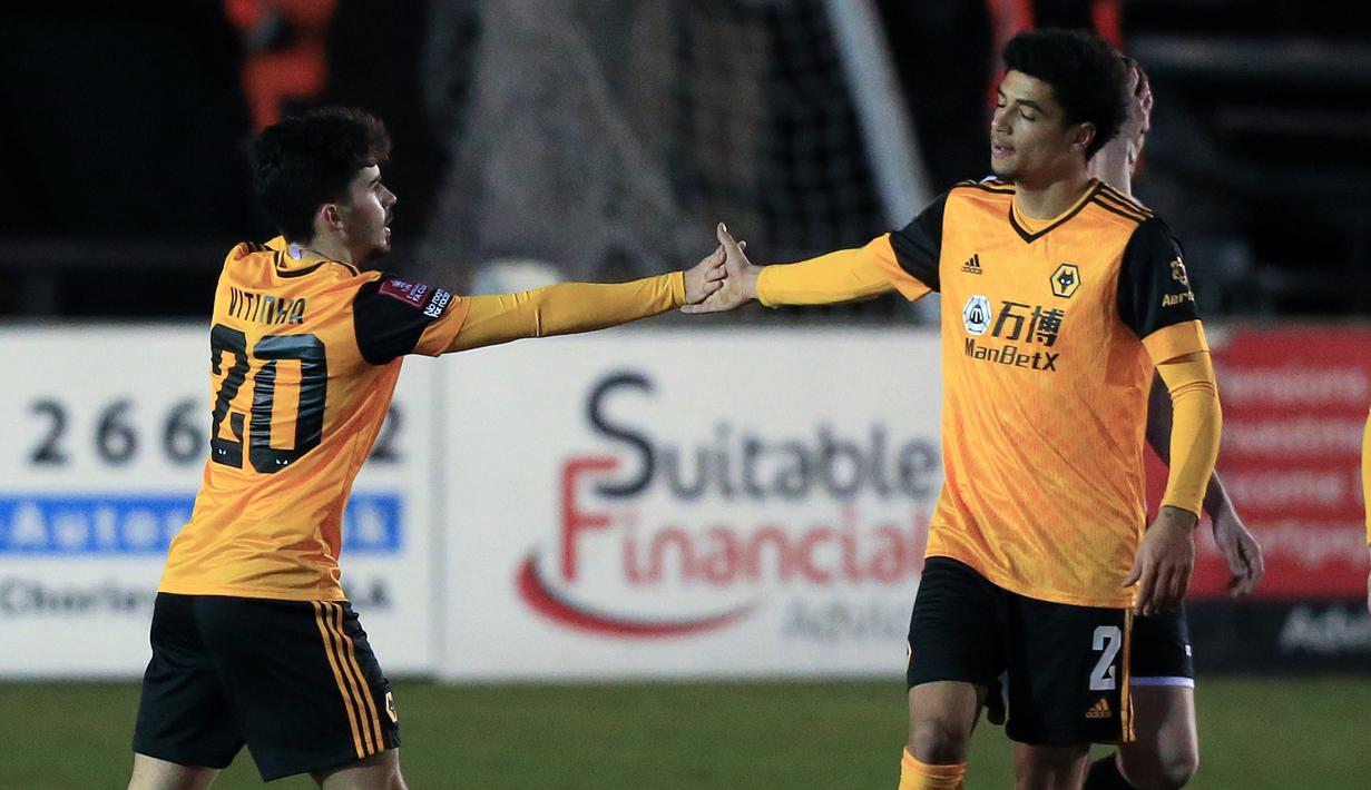 Gelandang Wolverhampton Wanderers, Vitinha (kiri) bersama rekan setim merayakan gol ke gawang Chorley dalam laga babak keempat Piala FA 2020/21 di Victory Park Stadium, Jumat (22/1/2021). Wolverhampton menang 1-0 atas Chorley. (AFP/Lindsey Parnaby)