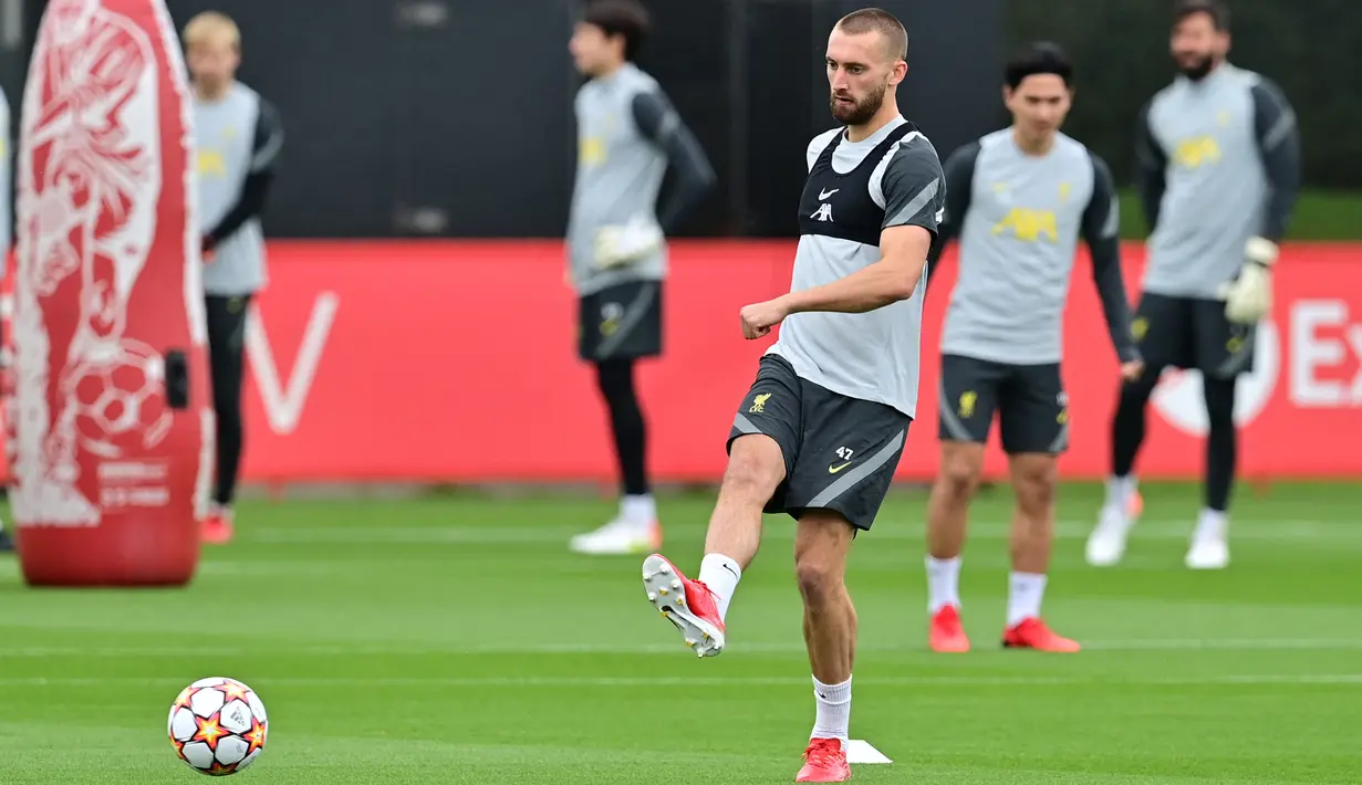 Bek Liverpool, Nathaniel Phillips mengumpan bola selama sesi latihan di pusat pelatihan Axa di Kirkby, Liverpool, Inggris (14/9/2021). Liverpool akan bertanding melawan wakil Italia, AC Milan pada Grup B Liga Champions di Anfield. (AFP/Paul Ellis)