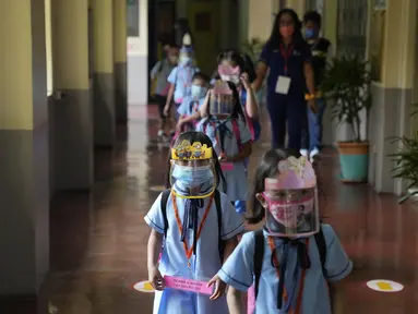 Siswa TK dengan masker dan pelindung wajah berjalan pada hari pertama kelas tatap muka di sekolah dasar Comembo di kota Makati, Filipina, Senin (6/12/2021). Beberapa sekolah di Manila diizinkan dibuka kembali setelah berbulan-bulan lamanya karena kasus COVID-19 terus menurun. (AP Photo/Aaron Favila)