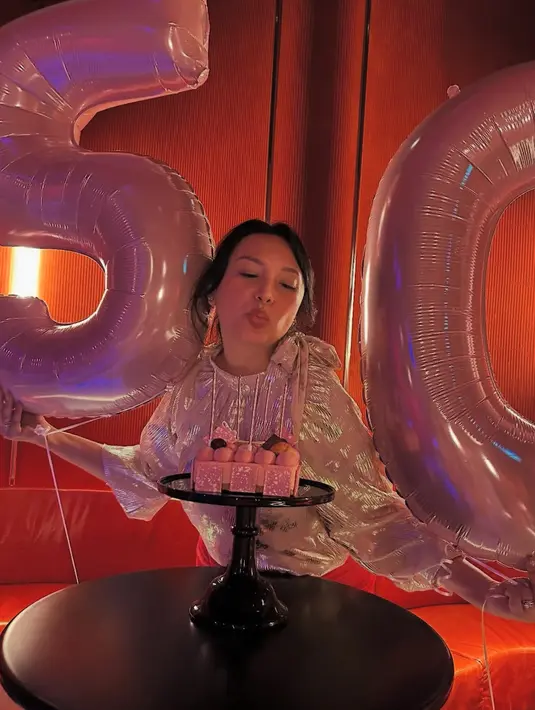 Di ruangan dengan nuansa merah ini, Tata terlihat memegang balon angka 5 dan 0 dengan ukuran cukup besar, menandakan usia barunya. Tampak ia pun mendapatkan cake pink sesuai dengan warna balonnya.  [@tatacahyani]