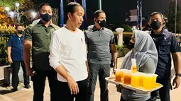 Presiden Joko Widodo berbincang dengan pedangan minuman di kawasan Malioboro, Daerah Istimewa Yogyakarta pada Sabtu malam, 15 Oktober 2022. Tidak hanya menyapa, Kepala Negara yang mengenakan kaos putih lengan panjang juga menyerahkan bantuan kepada pedagang asongan dan pedagang kaki lima yang berada di kawasan Malioboro. (Foto: Laily Rachev - Biro Pers Sekretariat Presiden)