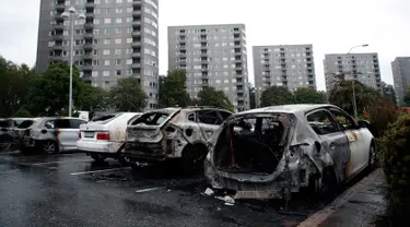 Deretan mobil yang terparkir di kota Gothenburg, Swedia hangus dan rusak, Selasa (14/8). Sekelompok orang bertopeng dan berpakaian hitam dilaporkan menjadi pelaku pembakaran puluhan mobil di sejumlah kota dalam semalam. (Adam Ihse/TT via AP)