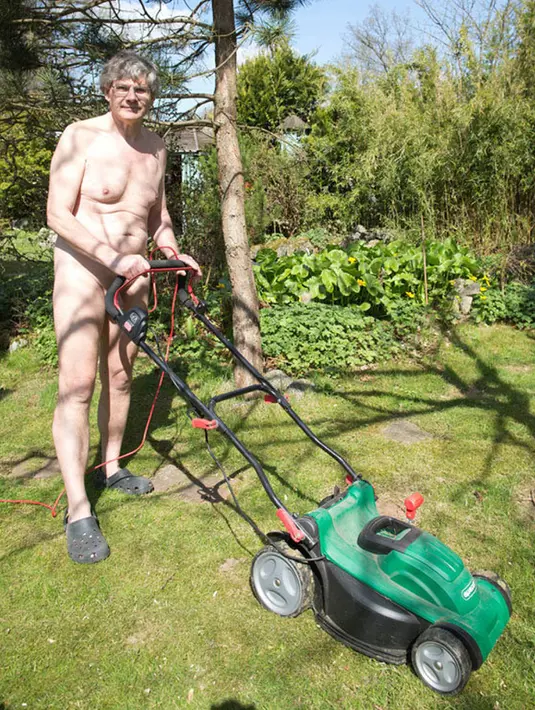 Warga saat mencukur rumput di depan halaman rumah di Desa Spielplatz, London, Inggris. Semua penduduk di desa tersebut beraktivitas tanpa selembar busana pun, alias telanjang bulat di musim panas. (ALAMY/dailystar.co.uk)