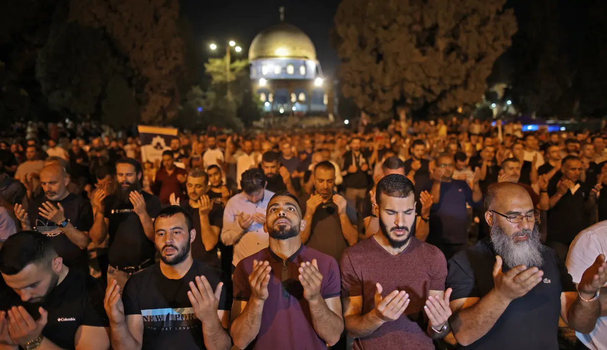 Umat muslim Palestina terlihat khusyuk berdoa saat berburu Lailatul Qadar di malam ganjil 27 Ramadan di luar Kubah Batu (Dome of the Rock) di kompleks Masjid Al-Aqsa di Yerusalem (8/5/2021). (AFP/Ahmad Gharabli)