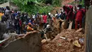 Tim penyelamat mencari korban setelah rumah runtuh setelah rumah runtuh setelah hujan lebat di distrik Attecoube di Abidja, Pantai Gading (16/6/2022). Enam orang tewas semalam setelah hujan lebat memicu tanah longsor di ibu kota ekonomi Pantai Gading Abidjan, kata layanan darurat. (AFP/Issouf Sanogo)