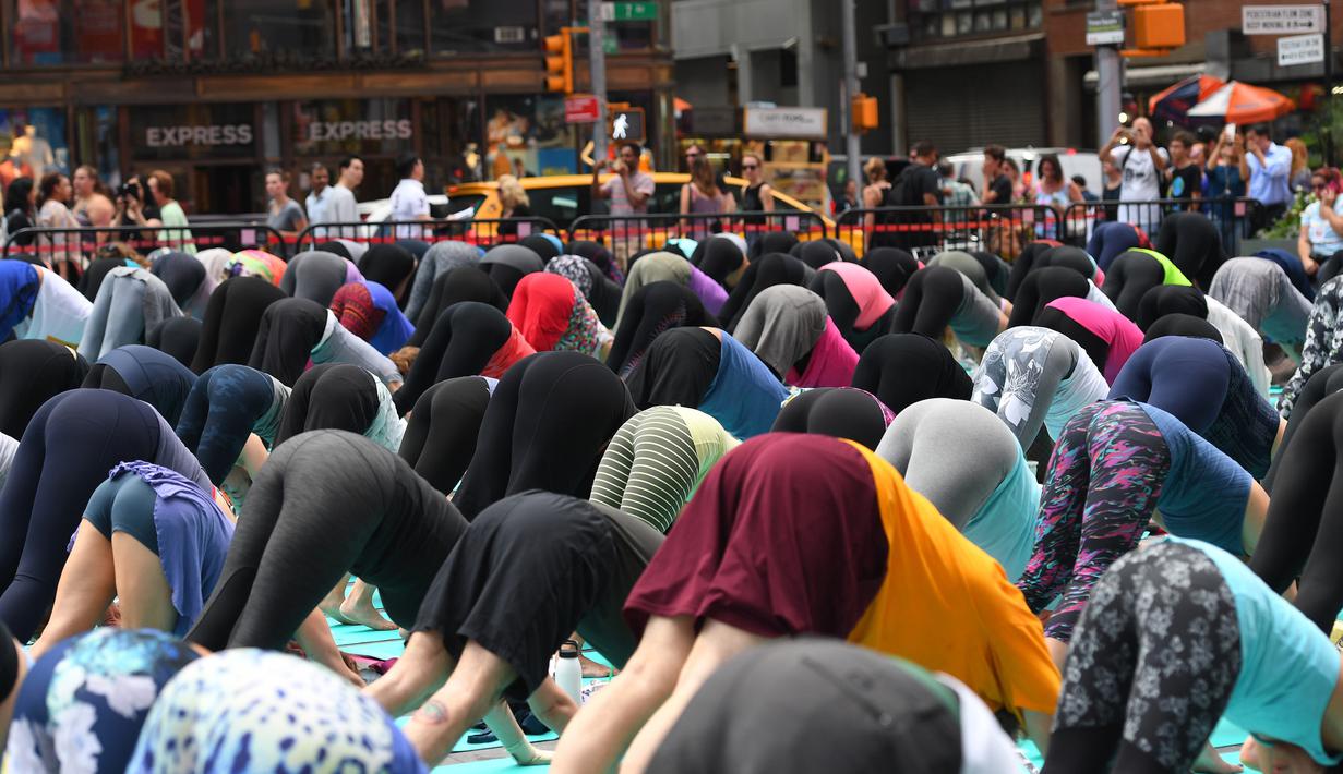 Sejumlah orang melakukan gerakan yoga di tengah jalan Times Square, New York pada 'Summer Solstice' atau hari dengan siang terpanjang di musim panas, Rabu (21/6). Acara itu menandai Hari Yoga Internasional yang jatuh pada 21 Juni. (TIMOTHY A. CLARY/AFP)