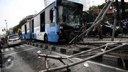 Kondisi bus gandeng TransJakarta yang menabrak pagar pembatas jalan di Jalan Gunung Sahari arah Markas Besar Angkatan Laut (MBAL), Jakarta, Selasa (6/9). Bagian depan bus ringsek dan kaca depan retak akibat tabrakan itu. (Liputan6.com/Faizal Fanani)