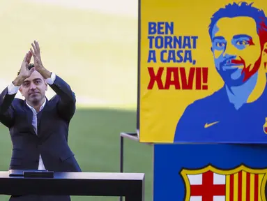 Pelatih baru Barcelona Xavi Hernandez melambai ke penonton saat presentasi resminya di stadion Camp Nou, Spanyol, Senin (8/11/2021). Xavi, yang berkembang di lini tengah Barcelona bersama Messi dan Andres Iniesta, secara resmi diperkenalkan sebagai pelatih Barcelona. (AP Photo/Joan Monfort)