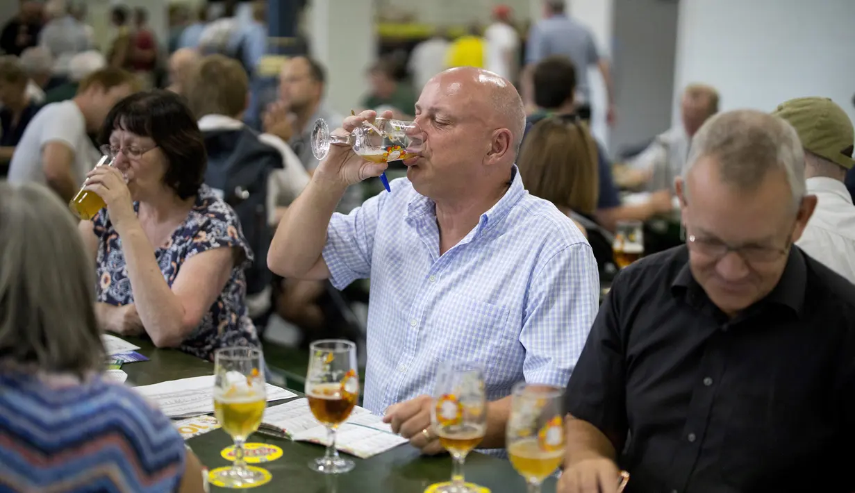 Seorang pria menikmati minum bir selama The Great British Beer Festival di Kensington Olympia di London barat (6/8/2019). Great British Beer Festival tahunan ini diadakan 6-10 Agustus 2019. (AFP Photo/Tolga Akmen)