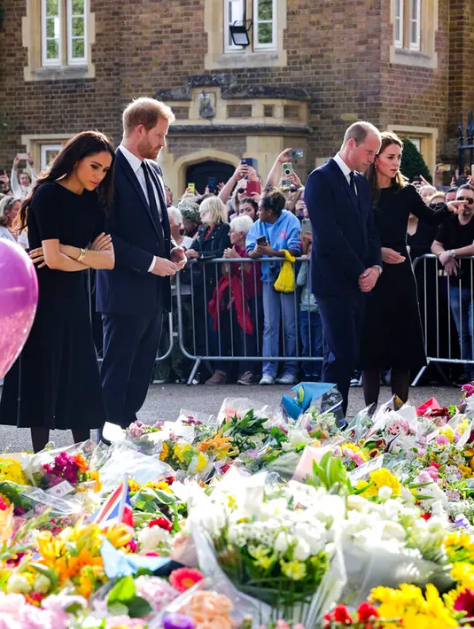 (kiri ke kanan) Meghan Markle dan Pangeran Harry bersama Pangeran William dan Kate Middleton melihat bunga untuk mendiang Ratu Elizabeth II di luar Kastil Windsor, Windsor, Inggris, 10 September 2022. Warga yang berada di Kastil Windsor untuk memberi penghormatan kepada Ratu Elizabeth II pun bersorak menyambut kehadiran William dan Kate serta Harry dan Meghan. (Chris Jackson/Pool Photo via AP)
