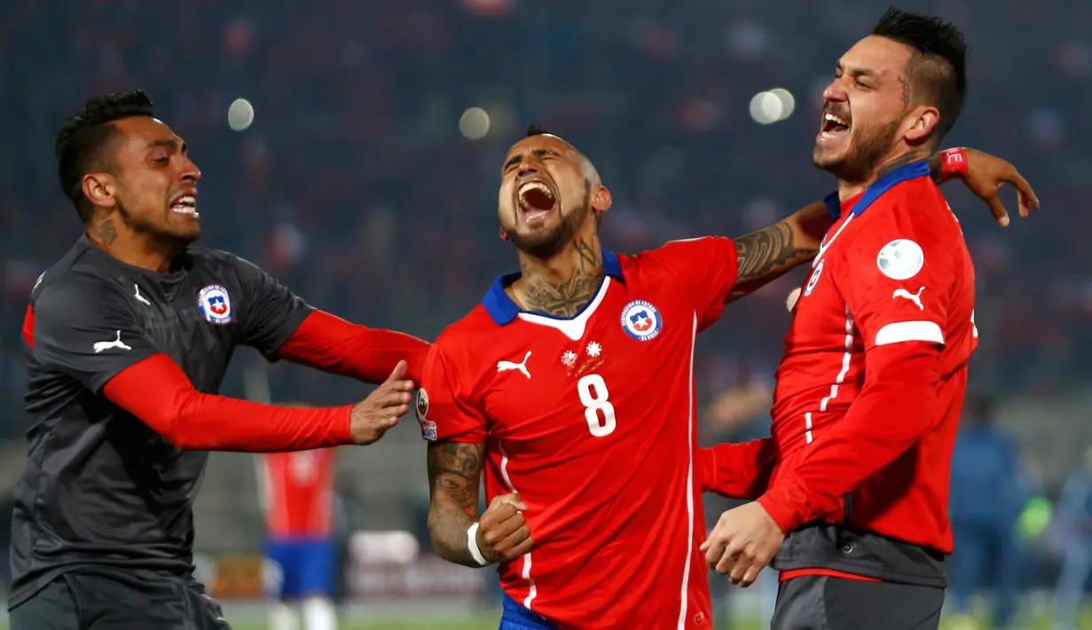 Arturo Vidal (tengah) bersorak merayakan kemenangan negaranya usai mengalahkan Argentina di Final Copa America 2015 di Stadion Nasional, Santiago, Chili, (4/7/2015). Chili menang lewat adu penalti atas Argentina dengan skor 4-1. (REUTERS/Marcos Brindicci)
