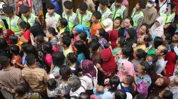 Aparat kepolisian disiagakan saat pembagian paket sembako Ramadan dari BUMN di Kecamatan Penjaringan, Jakarta, Selasa (13/6). Sebanyak 14 perusahaan BUMN yang turut serta dalam acara pembagian paket sembako se-Jabodetabek ini. (Liputan6.com/Angga Yuniar)